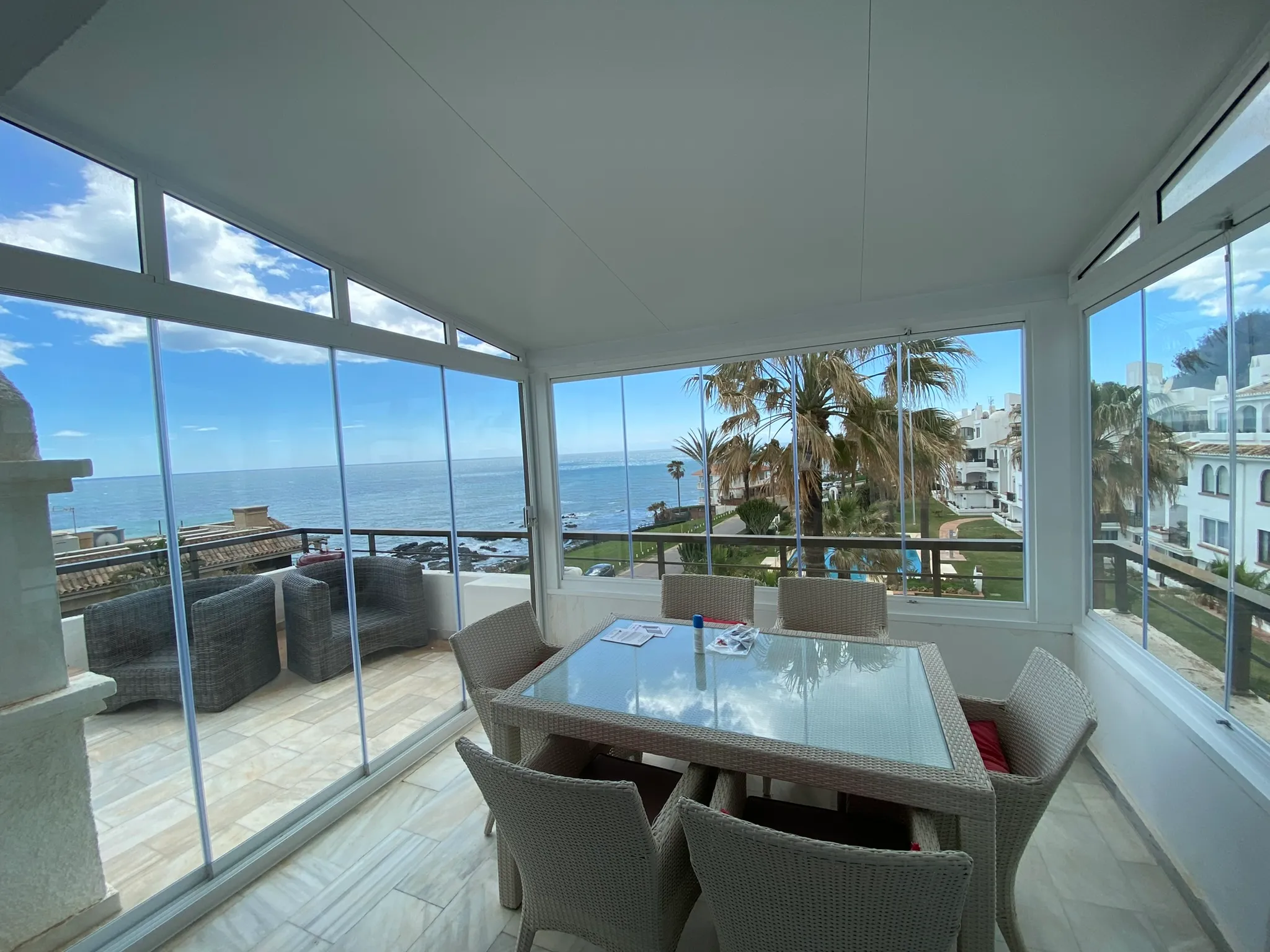 Frameless glass curtains framing a sea view from a Costa del Sol terrace